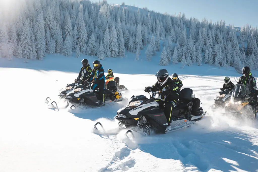 Guided group snowmobile ride through the snowy forests near Kolašin