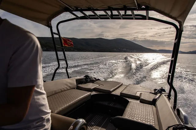 Covered seating and wake seen from inside the tour boat