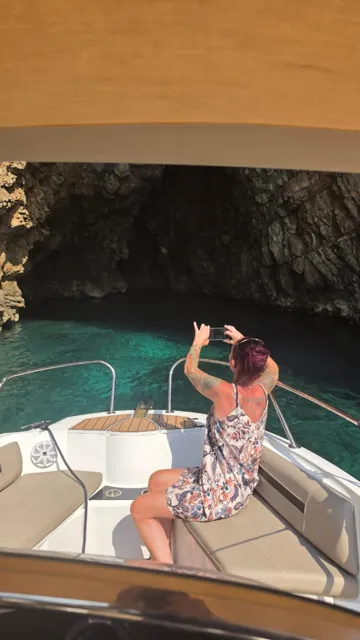 Guest enjoying coastal cave scenery from the boat