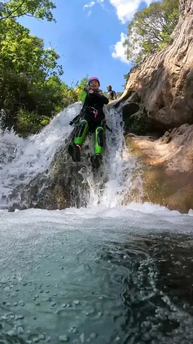 Guest sliding down a canyon waterfall