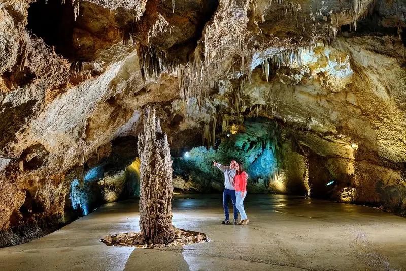 Visitor among large limestone formations in Lipa Cave