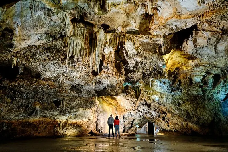 Visitors beneath large stalactites inside Lipa Cave