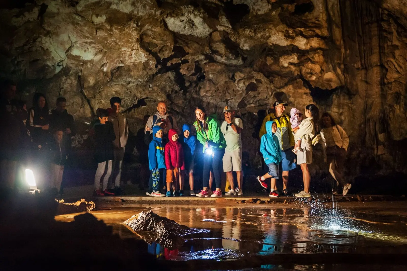 Group exploring a reflective chamber in Lipa Cave