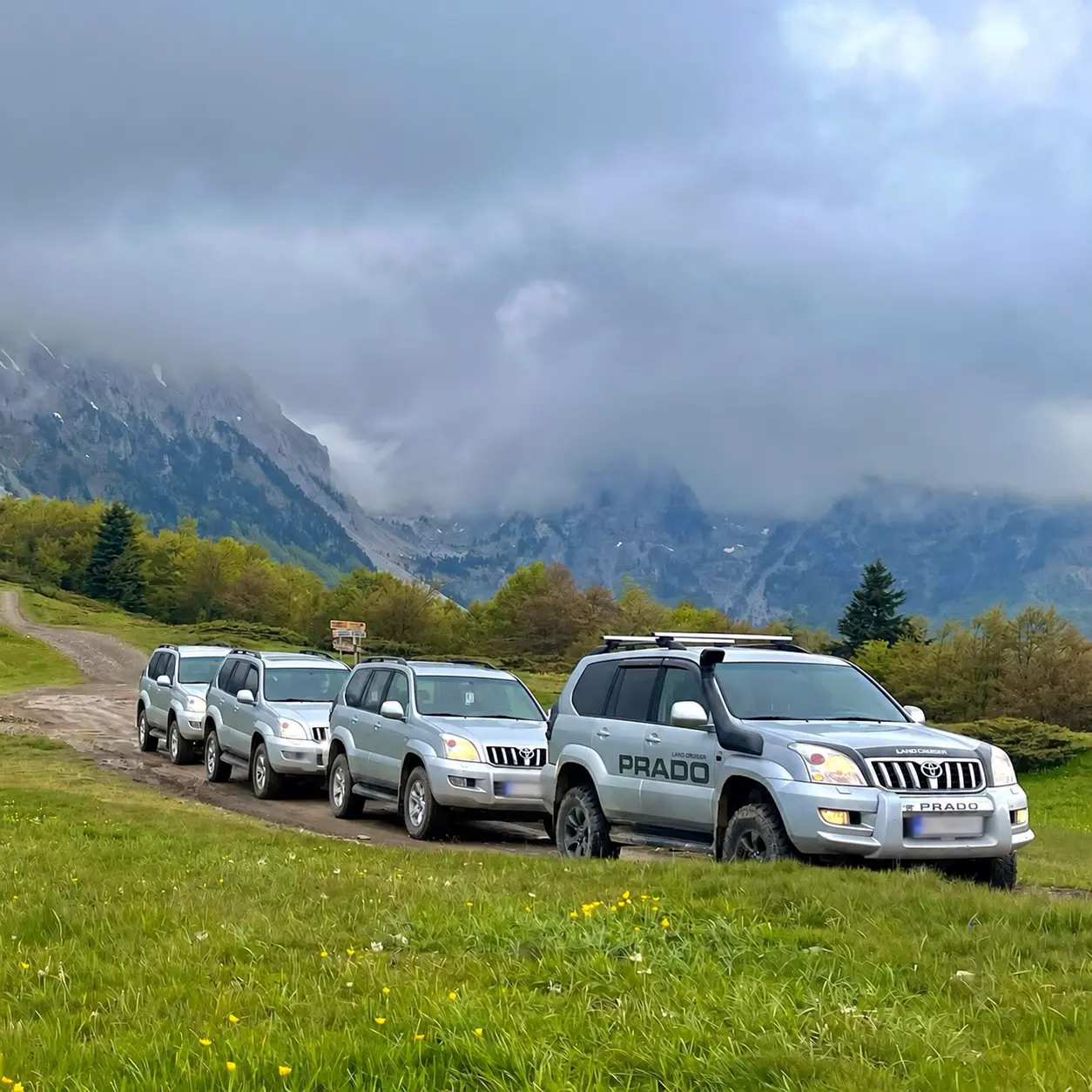Jeep convoy travelling below misty mountain peaks on the Ring of Bjelasica route